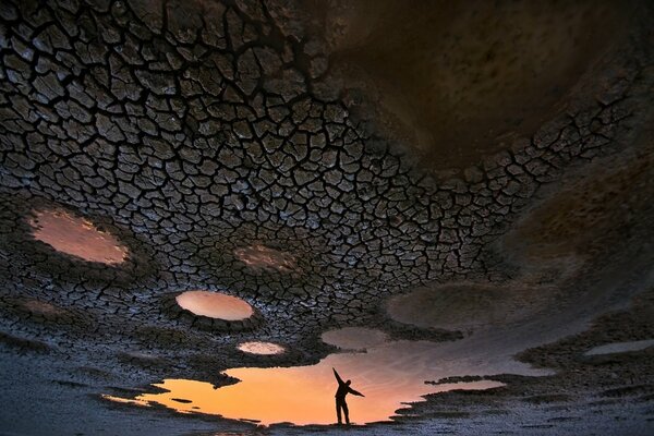 Reflection of a man s silhouette in a dried-up river