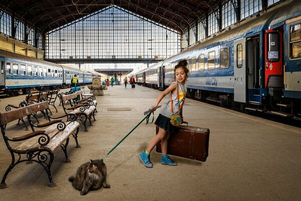 Ragazza con gatto al guinzaglio sul piazzale davanti al treno