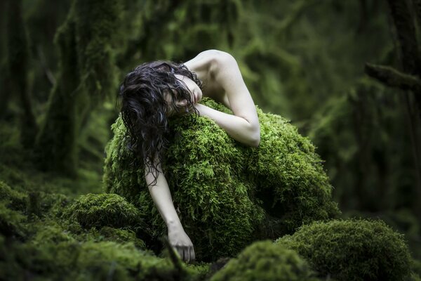 Pale girl in the forest on moss