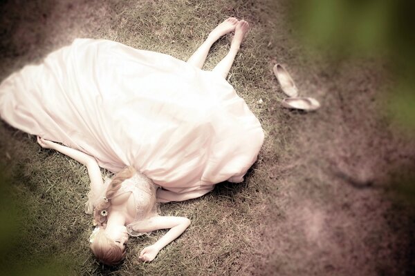 A girl in a white dress poses on the ground