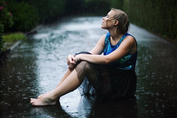 A girl in a blue dress in the rain