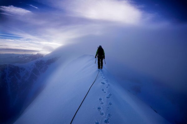 Escalador camina sobre montañas cubiertas de nieve