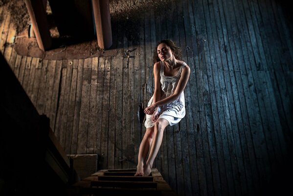 Une jeune femme est assise sur une chaise, mettre les pieds sur l escalier