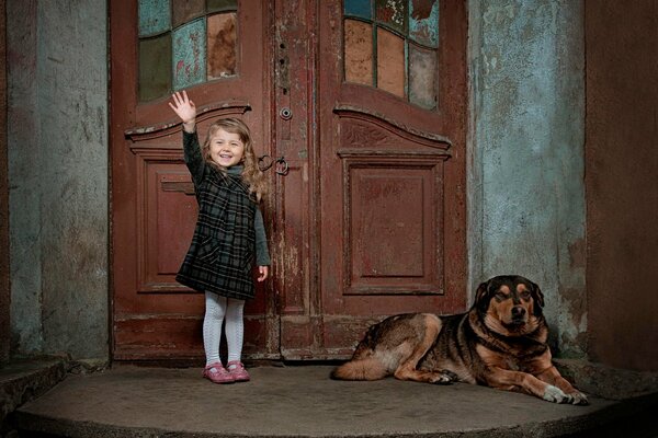A little girl with a dog next to the door