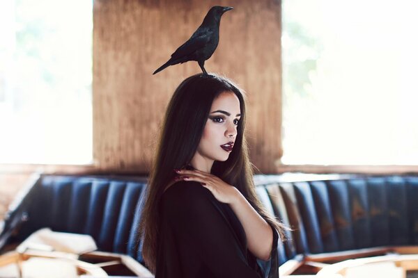 A crow is sitting on the girl s head