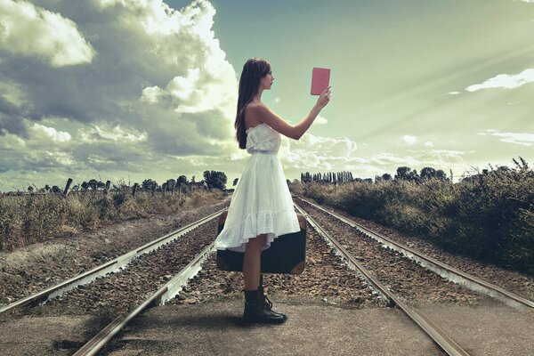 Ragazza sulla ferrovia con il libro in mano