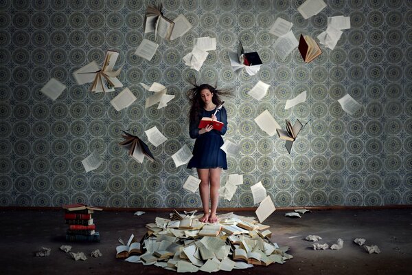 Mädchen in einem leeren Raum mit ausgebreiteten Buchblättern