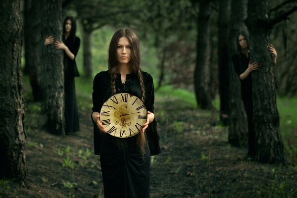 La jeune fille avec une horloge dans la forêt