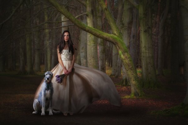 Mädchen in einem schönen Kleid mit einem Blumenstrauß und einem Hund