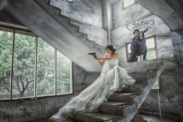 A girl in a wedding dress with a gun in her hands