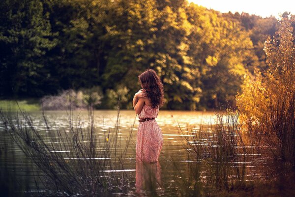 La jeune fille dans une robe rose dans l eau