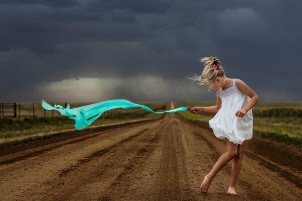 Jeune fille va sur la route dans la tempête