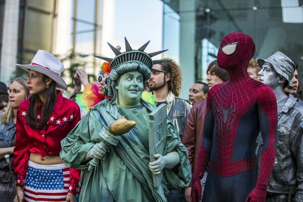 Personas vestidas con el traje de la estatua de la libertad y el hombre araña