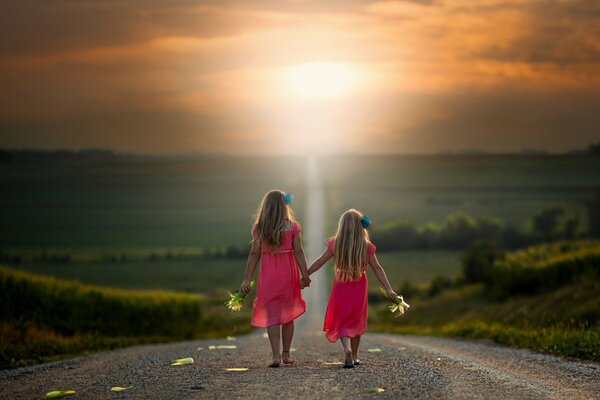 Dos chicas van de la mano en el camino