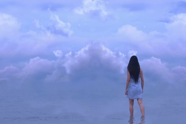Dziewczyna stoi w wodzie pod chmurami
