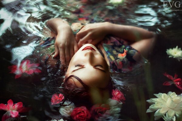 A girl lying on the water with flowers