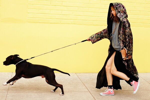 A girl on a walk with a dog on a leash