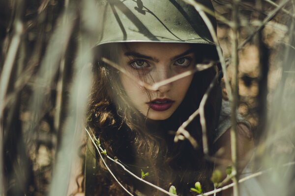 Through the branches, a girl in a helmet