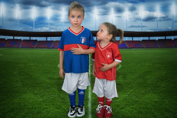 Niños pequeños en uniforme deportivo en el campo de fútbol