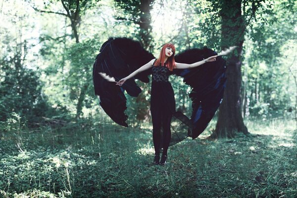La jeune fille avec des ailes de photos dans la forêt