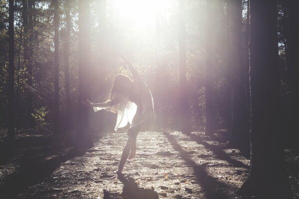 Chica bailando en un vestido blanco en el sol marido