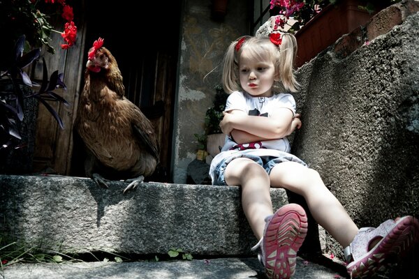 Photo of an offended girl and a chicken on the porch