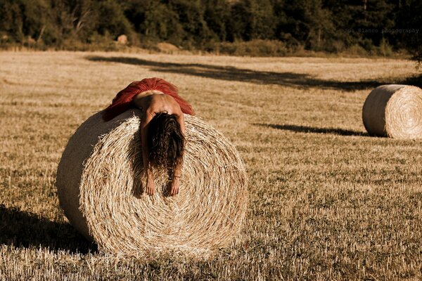 The girl is lying on a haystack