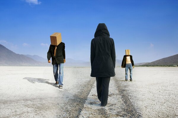 В пустыне идут с коробками на голове два мужика им навстречу идёт девушка в капюшоне