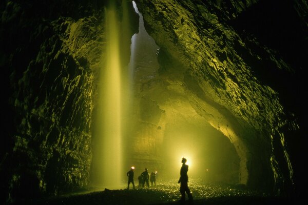 Photos de personnes dans une immense grotte sombre