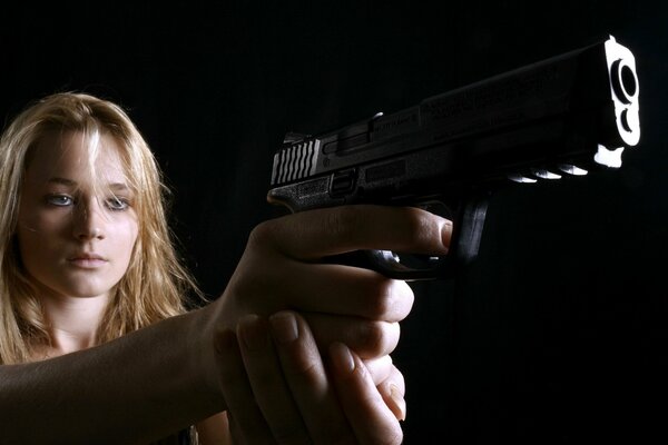 A gun in the hands of a beautiful woman