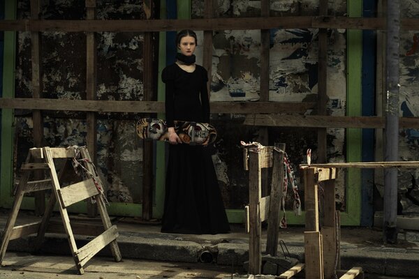 A girl in a black dress with a skateboard in her hands