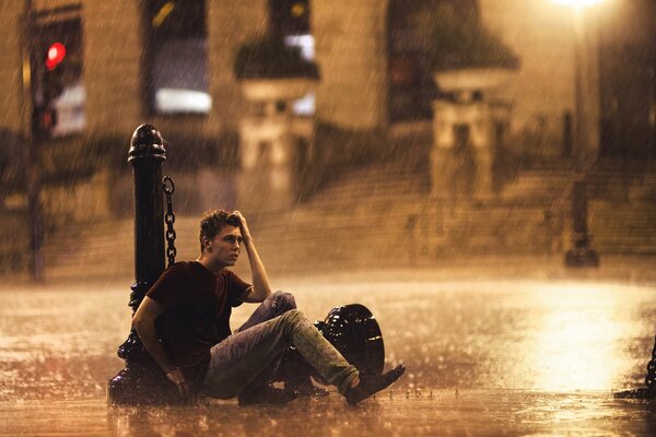 The guy is alone on the street in the rain