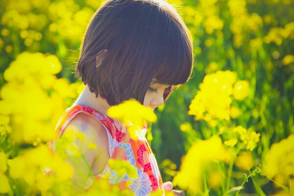 Ragazza di estate nel campo con i fiori