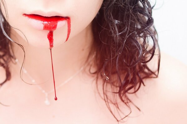 The girl s lips are covered in scarlet blood