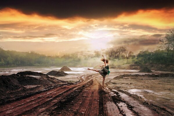 Chica bailando en la carretera en la lluvia. Naranja puesta de sol