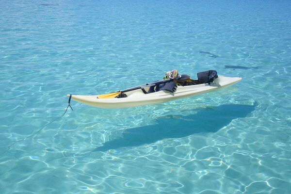 Boot mit Paddel im kristallklaren Wasser