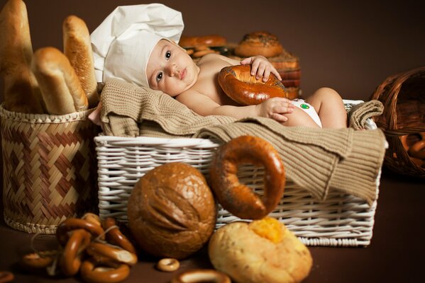 Fatigué bébé cuisinier dans un panier avec du pain