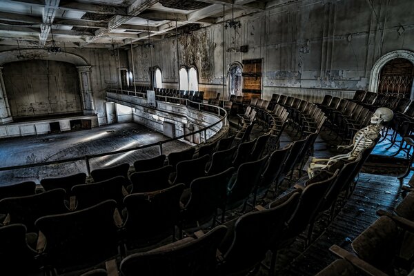 Squelette assis dans les gradins d un vieux théâtre abandonné