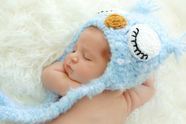 Małe dziecko śpi w niebieskiej czapce