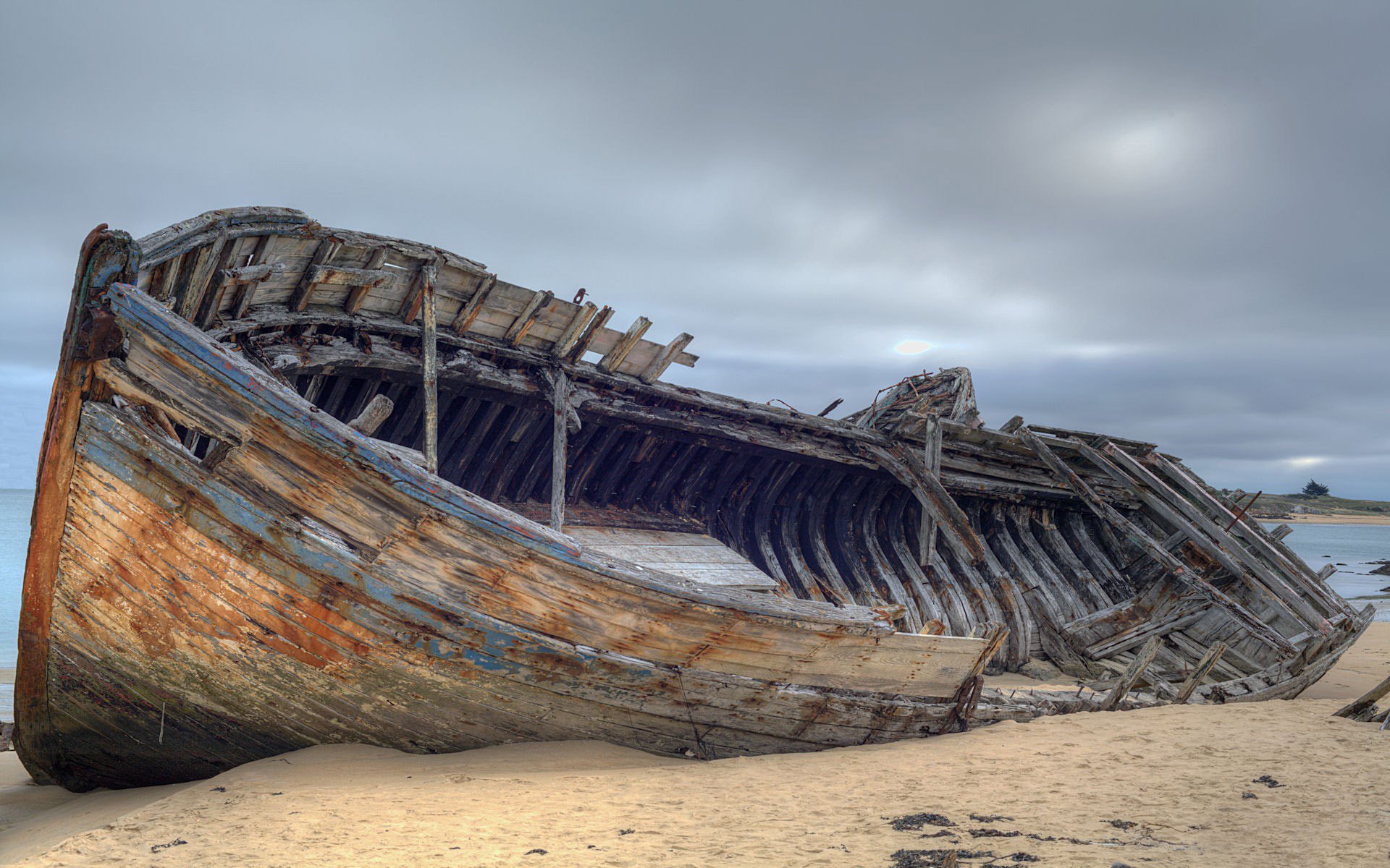 situation schiff boot schiff rahmen rumpf bretter holz trümmer ruinen ufer sand küste horizont himmel bewölkt moll stimmung