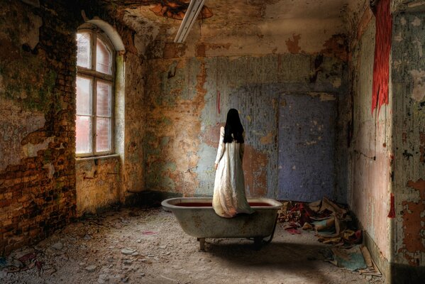 Chica en el baño en un edificio abandonado