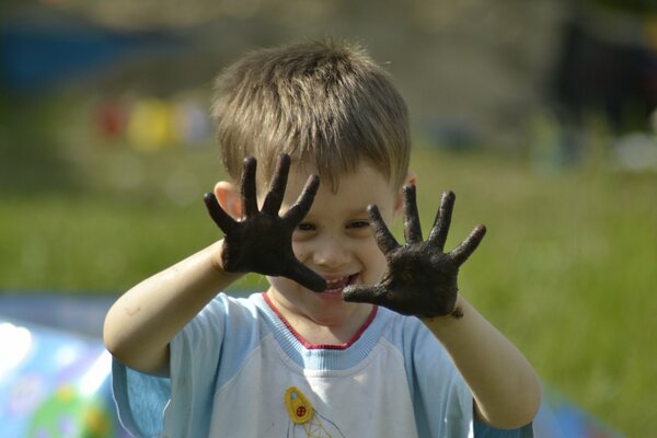 A child with dirty palms laughs