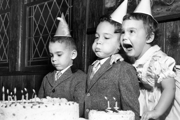 Les enfants soufflent des bougies sur le gâteau de vacances