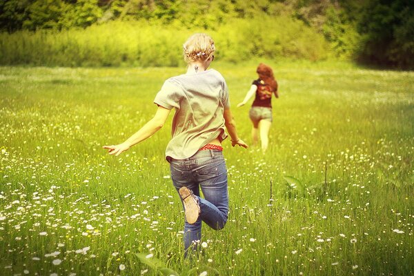 Chicas corriendo por el campo de las margaritas