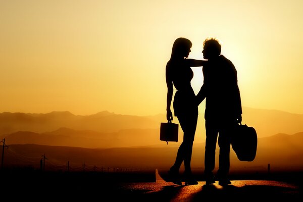 Silhouettes of a man and a woman at sunset