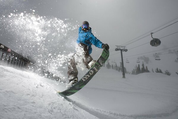 Photo of a snowboarder on the background of a cable car