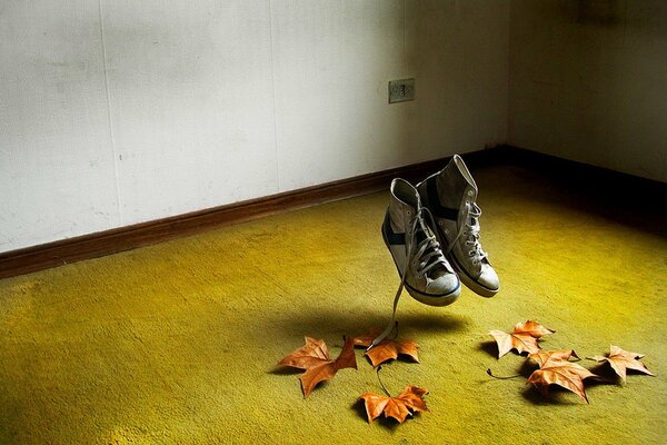 Autumn leaves. Old sneakers jump