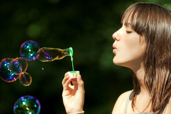 The girl blows soap bubbles