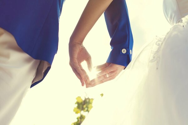 Les mains de la mariée et le marié en forme de coeur