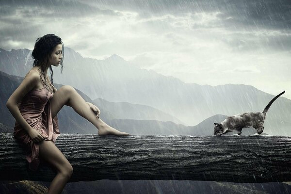 La jeune fille et le chat assis sous la pluie sur un tronc d arbre